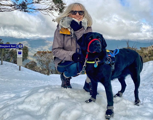 Deb crouches down next to Zazu in the snow