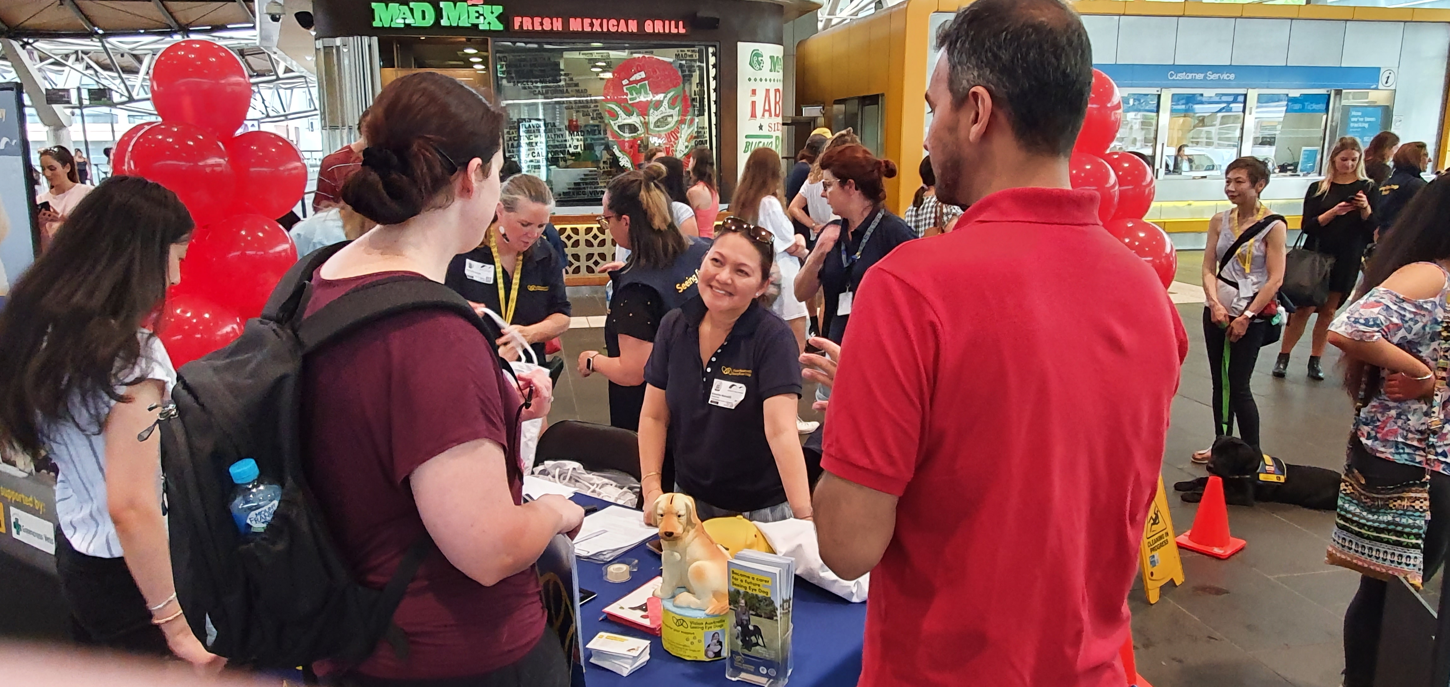  SED Team Member Monette runs the display table, passing on information to the commuters.