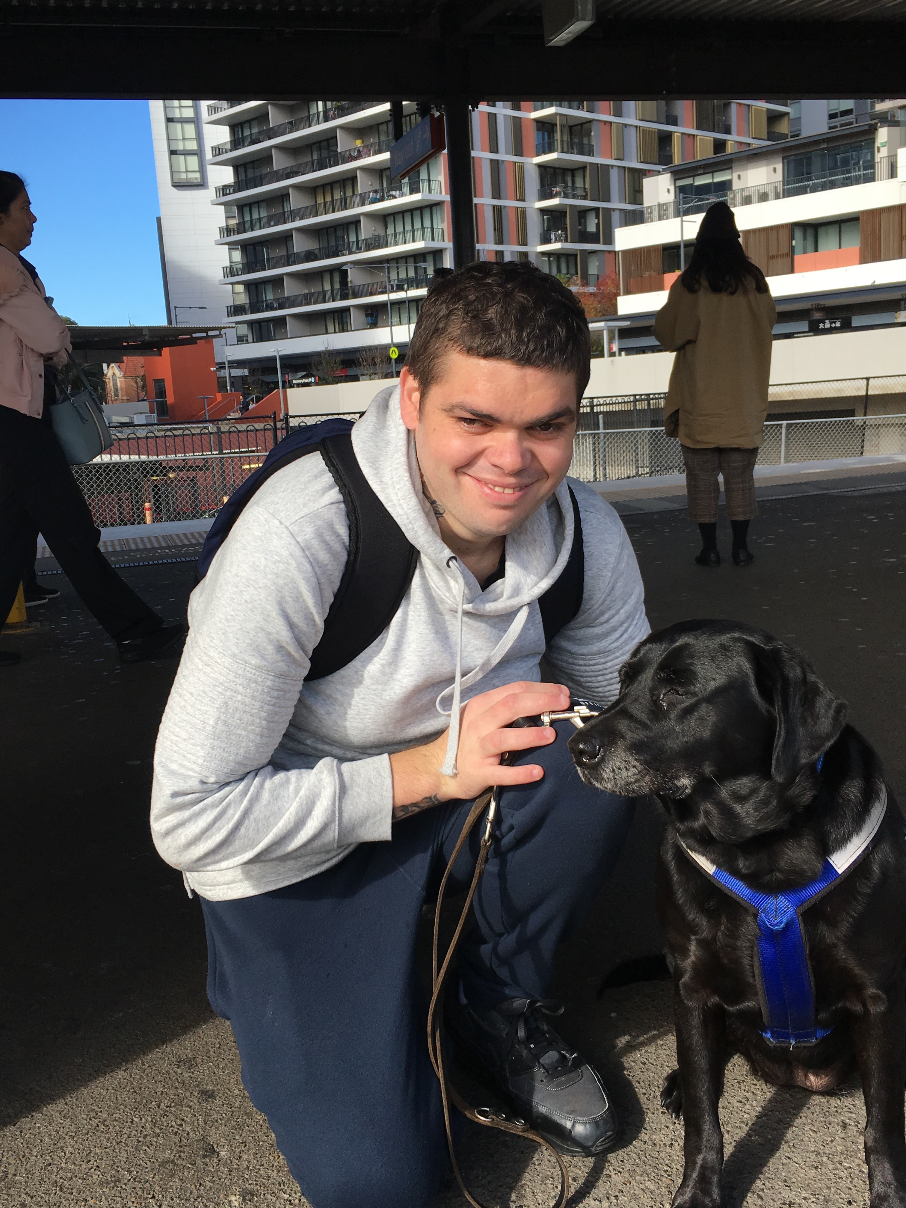 Brian sits with his black Labrador Seeing Eye Dog Opal