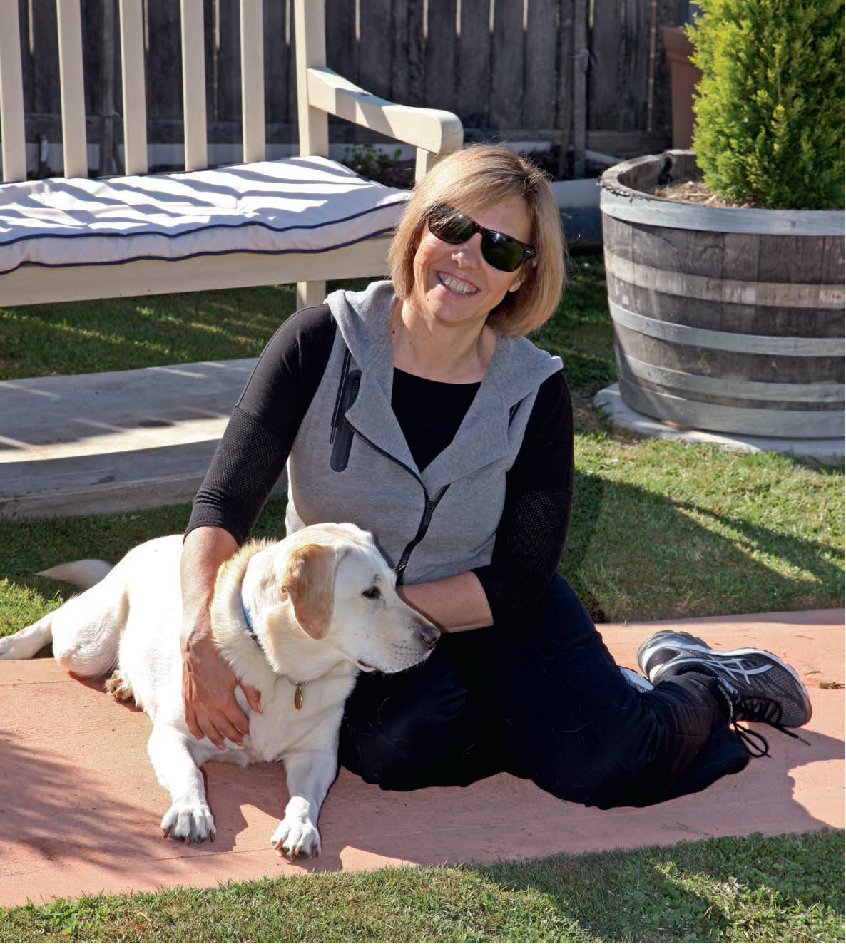 Lucia sits with her Seeing Eye Dog Aura in a garden.